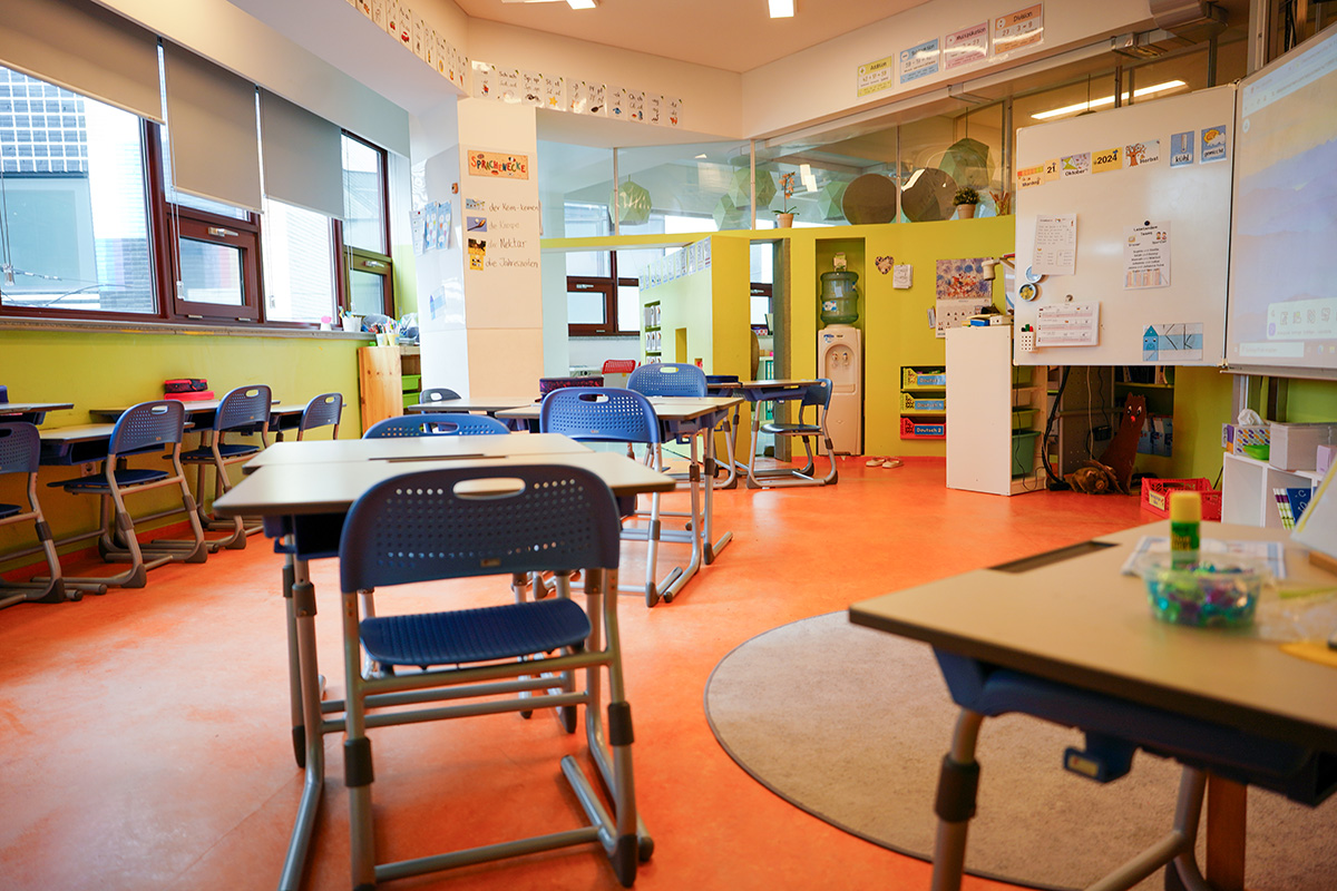 Ein Klassenzimmer an der Deutschen Schule Seoul International. Es sind Stühle, Tische und eine digitale Tafel zu sehen. An der Wand hängen Lernplakate.